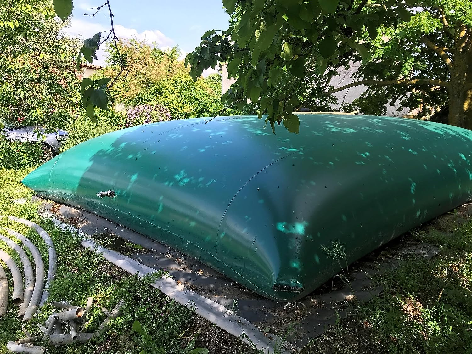 Citerne souple verte de 10000 litres sous un arbre